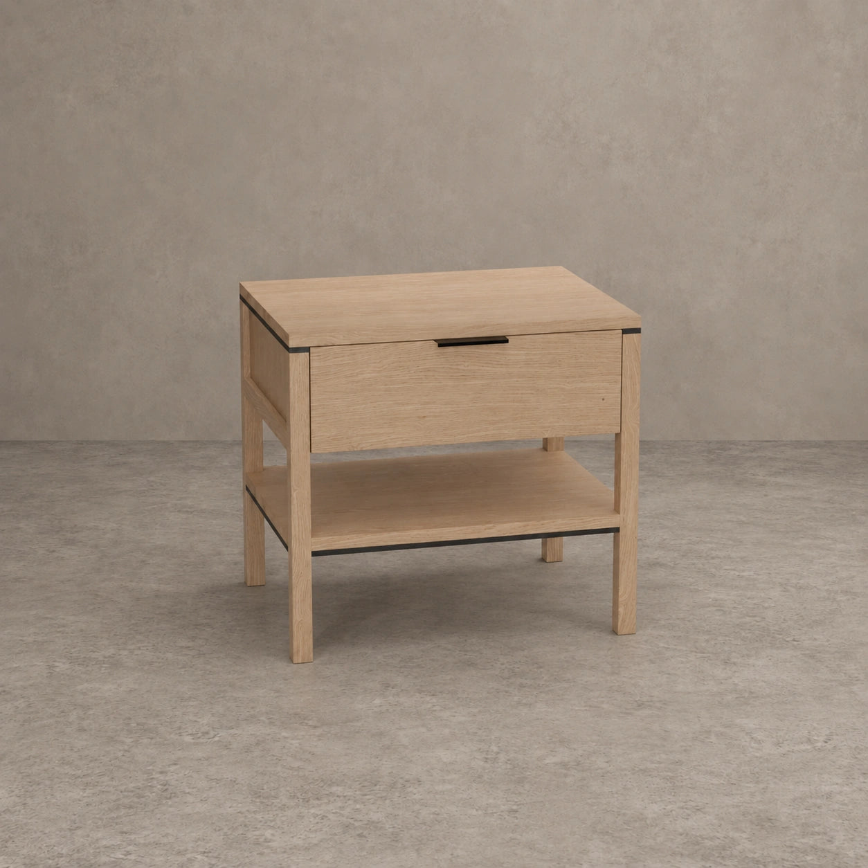 A light oak wood nightstand with a single drawer, an open lower shelf, and a slim black metal handle, set against a textured gray concrete wall and floor.
